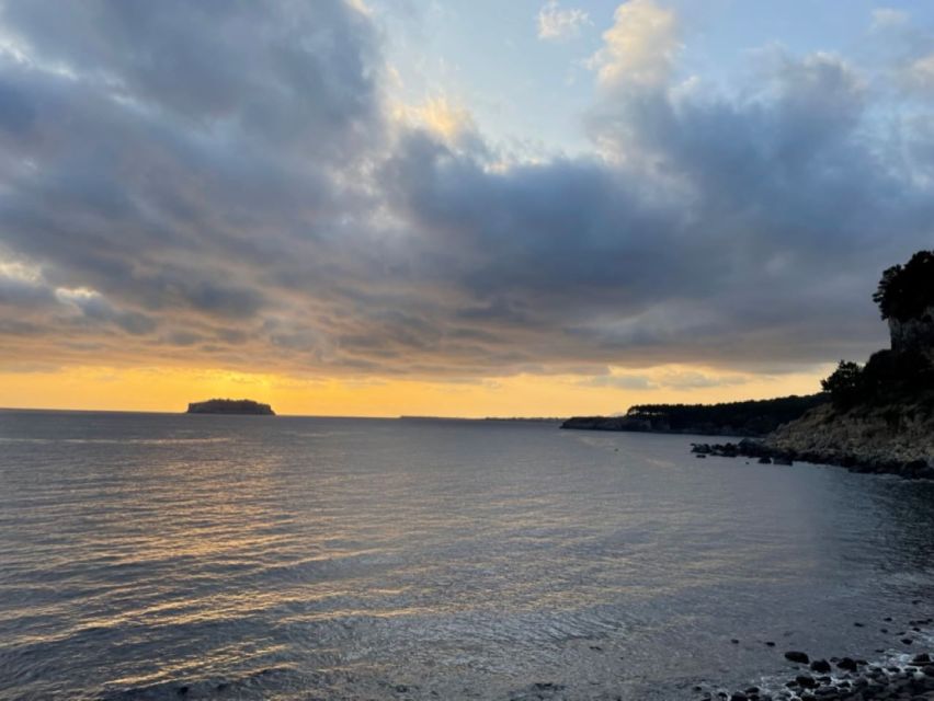 Jeju: Seogwipo City Walking Tours with Sunset - Crossing Saeyeongyo Bridge at sunset